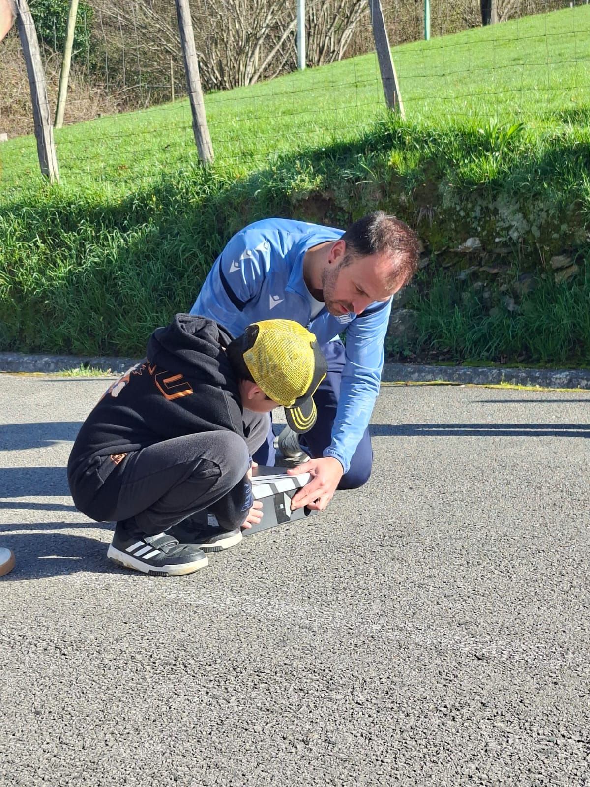 Asier Gogortza sacando una foto con un niño usando una cámara estenopeica.